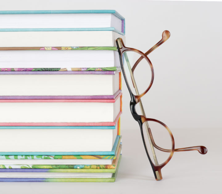 Stapel mit Kinderbüchern von Corinna Wieja, an den eine Brille gelehnt ist